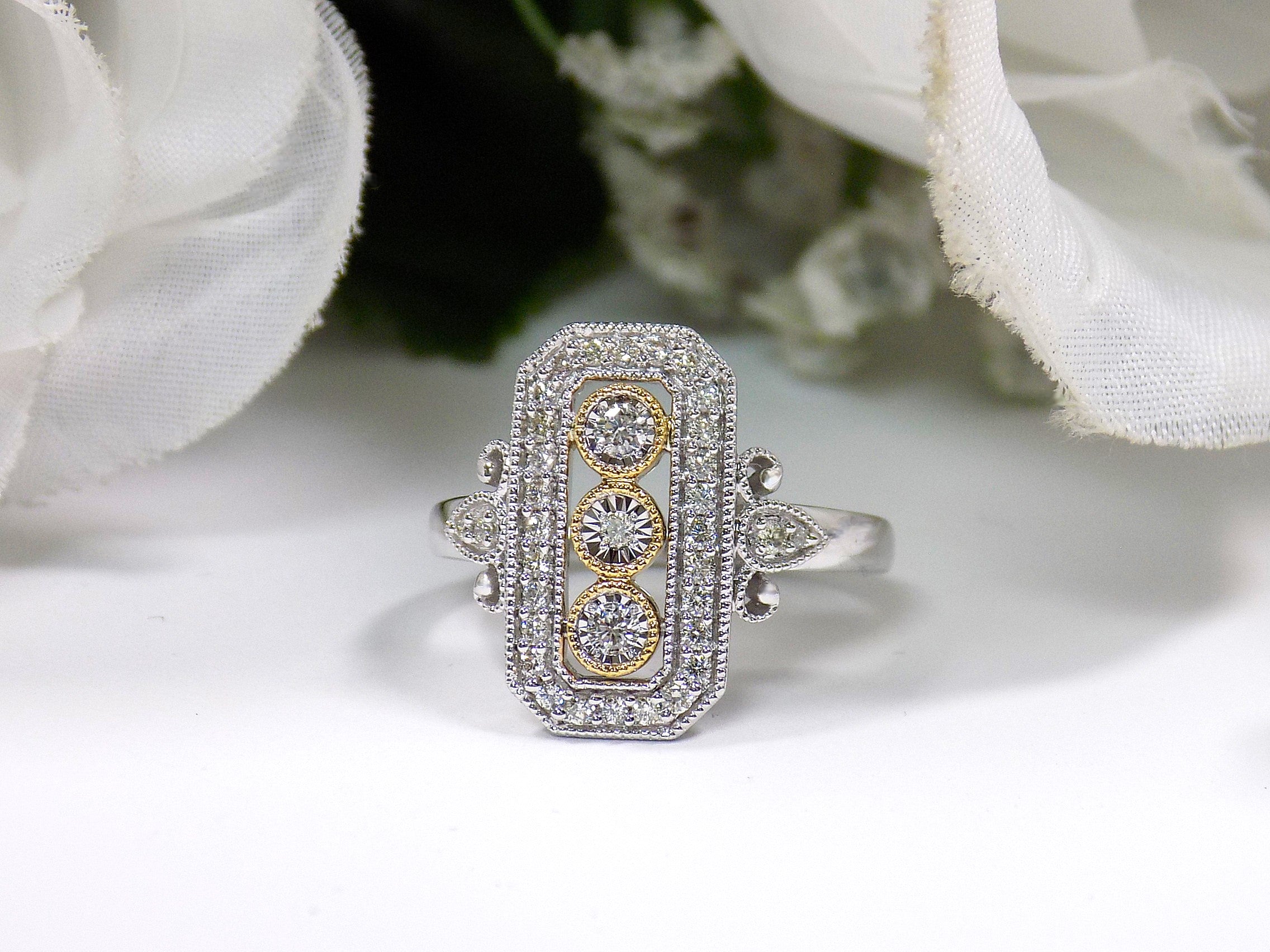 This ring is a filigree style natural diamond ring with a total of .37ct natural diamonds in 2-tone white and yellow gold on a white floral background.