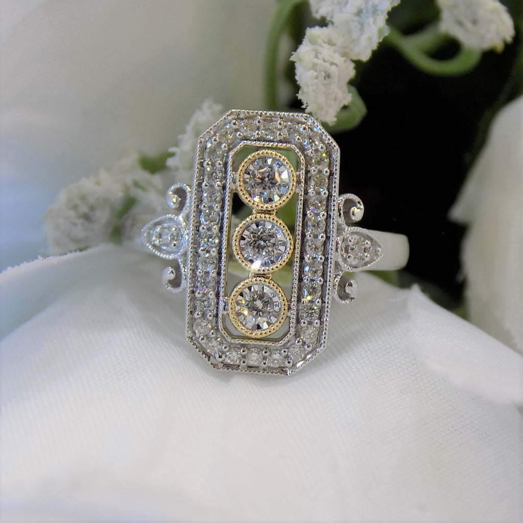 This ring is a filigree style natural diamond ring with a total of .37ct natural diamonds in 2-tone white and yellow gold on a white floral background.