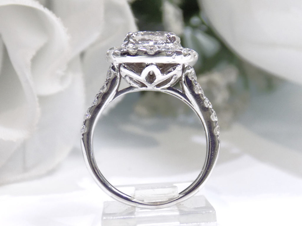 This is a side view of a 3.55ct total weight natural diamond ring with a 2.05ct natural round diamond center in white gold shown with a white background.