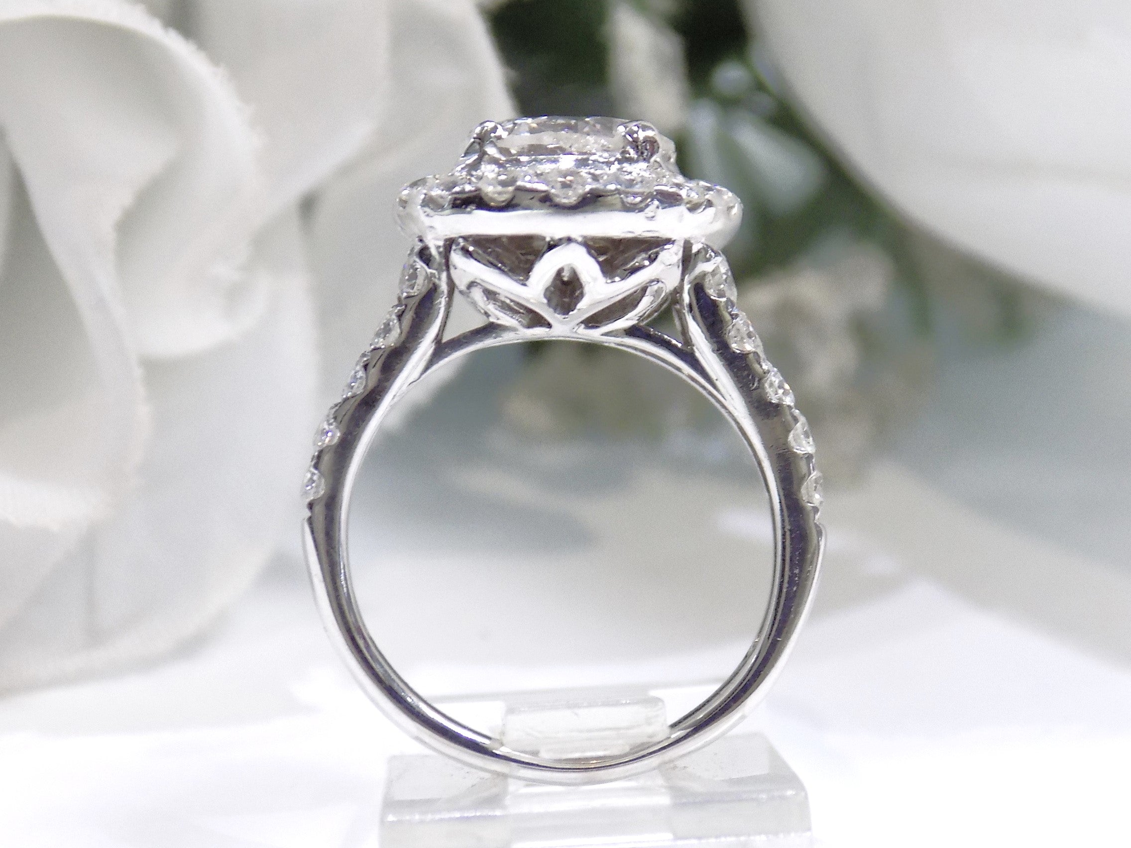 This is a side view of a 3.55ct total weight natural diamond ring with a 2.05ct natural round diamond center in white gold shown with a white background.