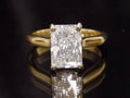 This is a 3.01ct Natural radiant cut diamond solitaire in yellow gold with a dark background.