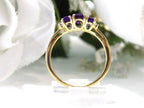This is a 1.25ct total weight 3-stone natural amethyst and round diamond  ring in 10K yellow gold side view with a white background.