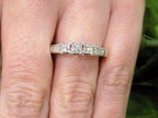 This is 3-Stone style .75ct total weight natural princess cut diamond ring in white gold shown on a woman's finger.