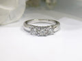 This is a 3-stone style natural .90ct total weight round diamond ring in white gold with a white background.
