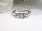 This is a 3-stone style natural .90ct total weight round diamond ring in white gold with a white background.