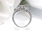 This is a side view 3-stone style natural .90ct total weight round diamond ring in white gold with a white background.