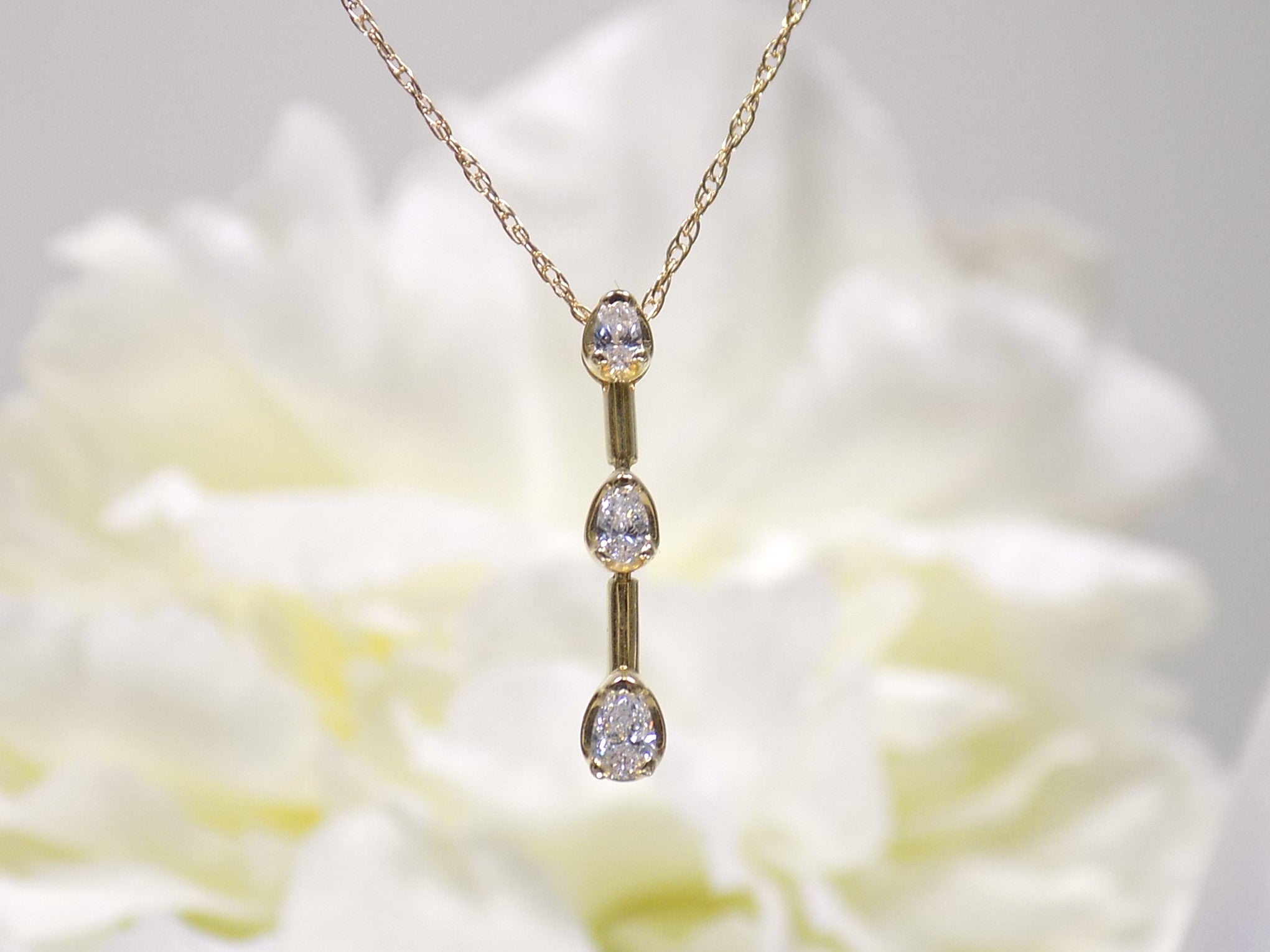 This is a vintage 3 stone necklace with .20ct total weight natural pear shape diamonds with a 14K yellow gold chain. 