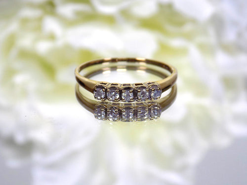 Preowned or estate small 5-stone natural diamond band in yellow.