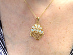 The is a genuine oval shape opal basket pendant in yellow gold from our estate collection in like new condition shown on woman's neck.