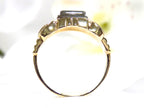 This is a side view of a natural antique diamond ring from the turn of the century in yellow and white gold with a white background.