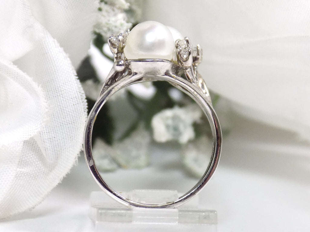 This is a side view of a twin cultured pearl ring with natural diamond accents in white gold shown on a white background.