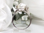 This is a side view of a twin cultured pearl ring with natural diamond accents in white gold shown on a white background.