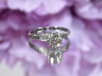 This an antique women's solitaire ring from the 1880's with natural old mine cut center shown with mirrored floral background.