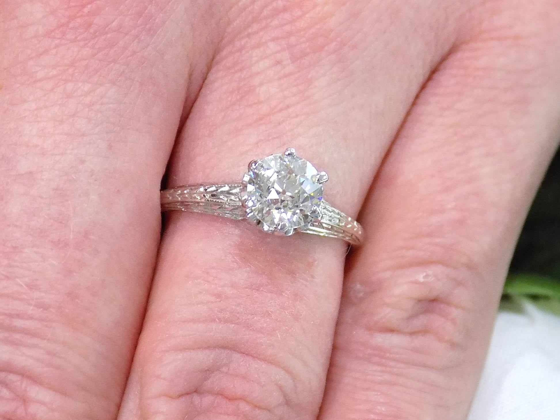 This an antique women's solitaire ring from the 1880's with 1ct natural old mine cut center shown on a woman's finger.