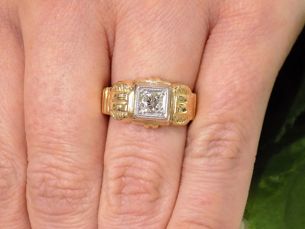 This is an natural antique diamond ring from the turn of the century in yellow and white gold shown on a Woman's finger.