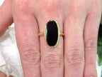 This is a vintage oval bezel set black onyx ring in 10K yellow gold.  It is 21mm long and 18mm wide on a woman's finger.