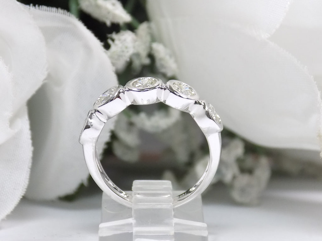 This is a 5 stone bezel set natural round diamond band in 14K white gold with a white background side view.