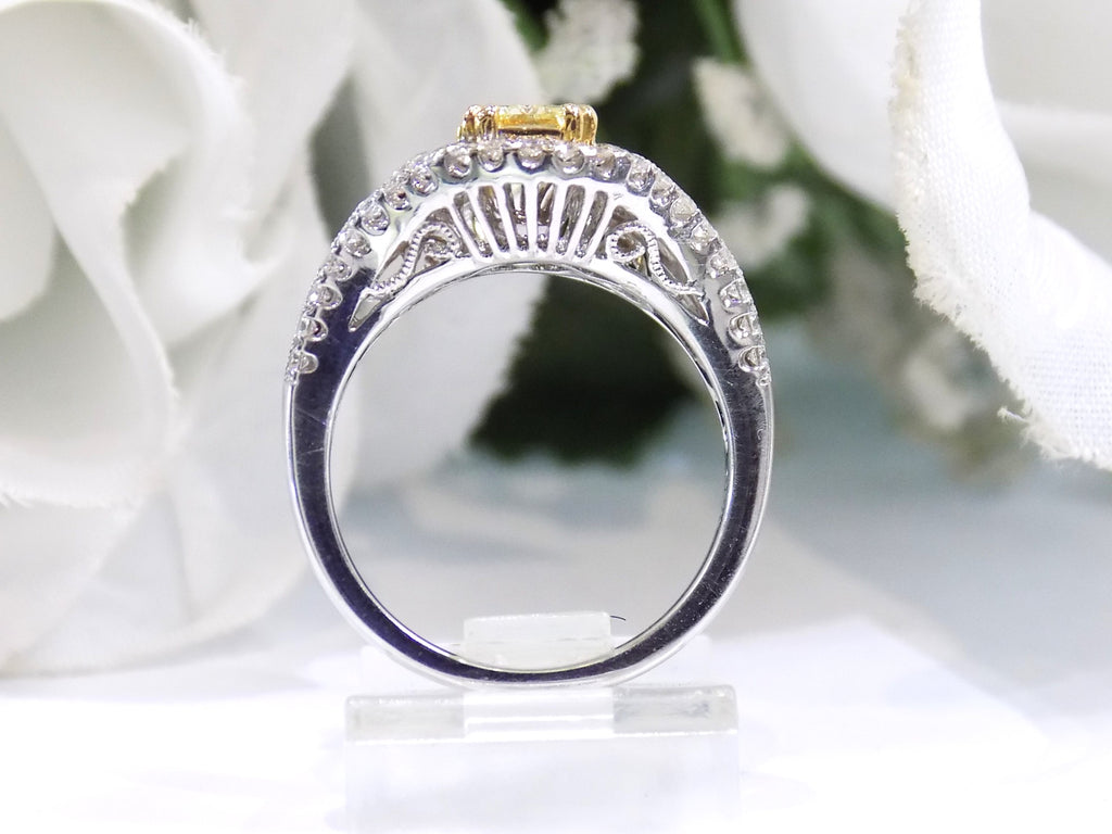 This is a side view of a 1.35ct total weight natural fancy yellow not enhanced diamond ring with white diamond accents in white gold with white flowery background.