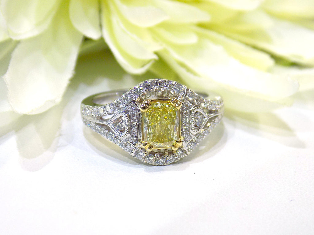 This is a 1.35ct total weight natural fancy yellow not enhanced diamond ring with white diamond accents in white gold with white flowery background.