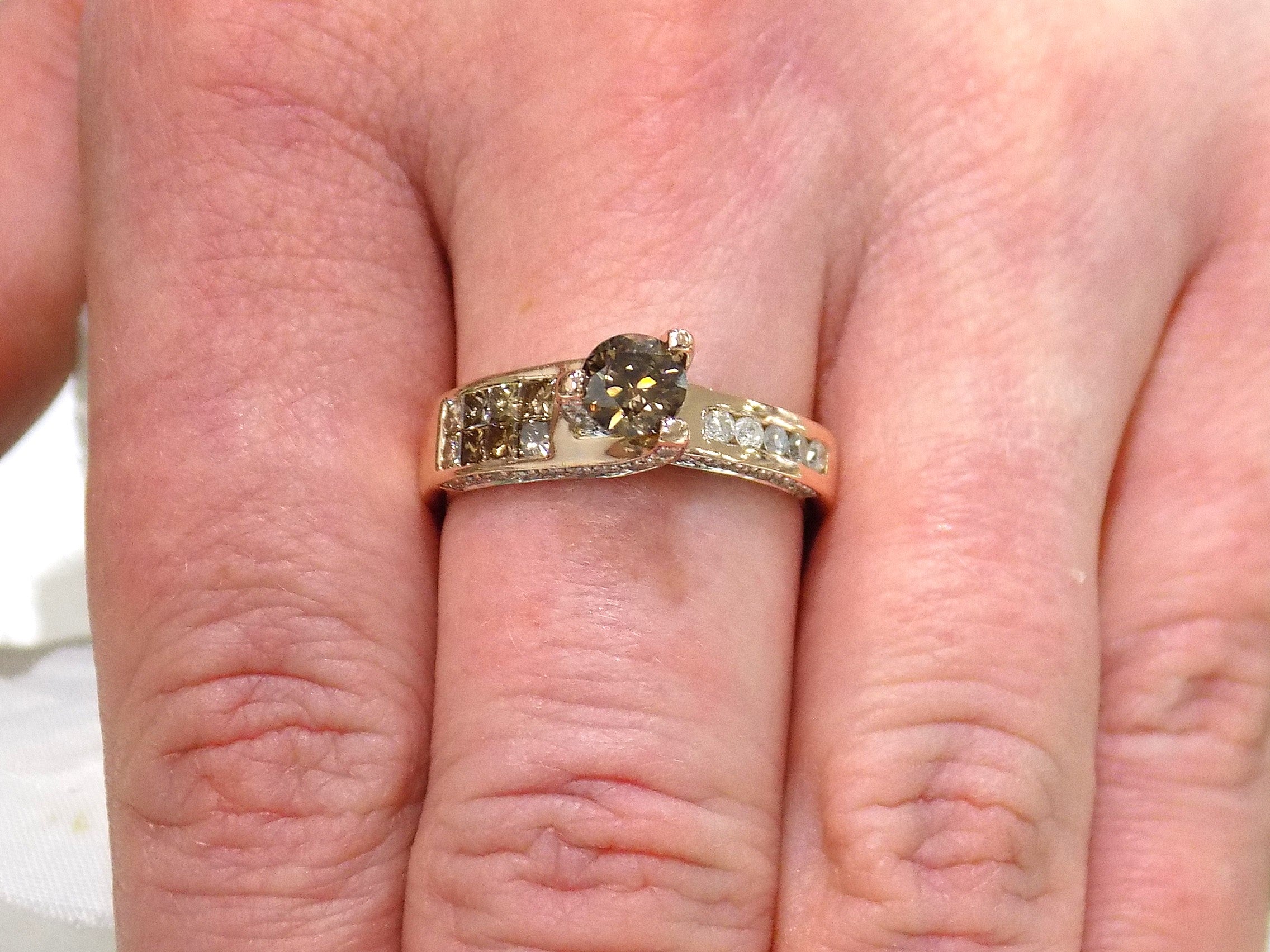 This is a very modern looking chocolate and white diamond ring in rose gold shown on a woman's finger.