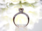 This is a very modern looking chocolate and white diamond ring in rose gold shown from the side.