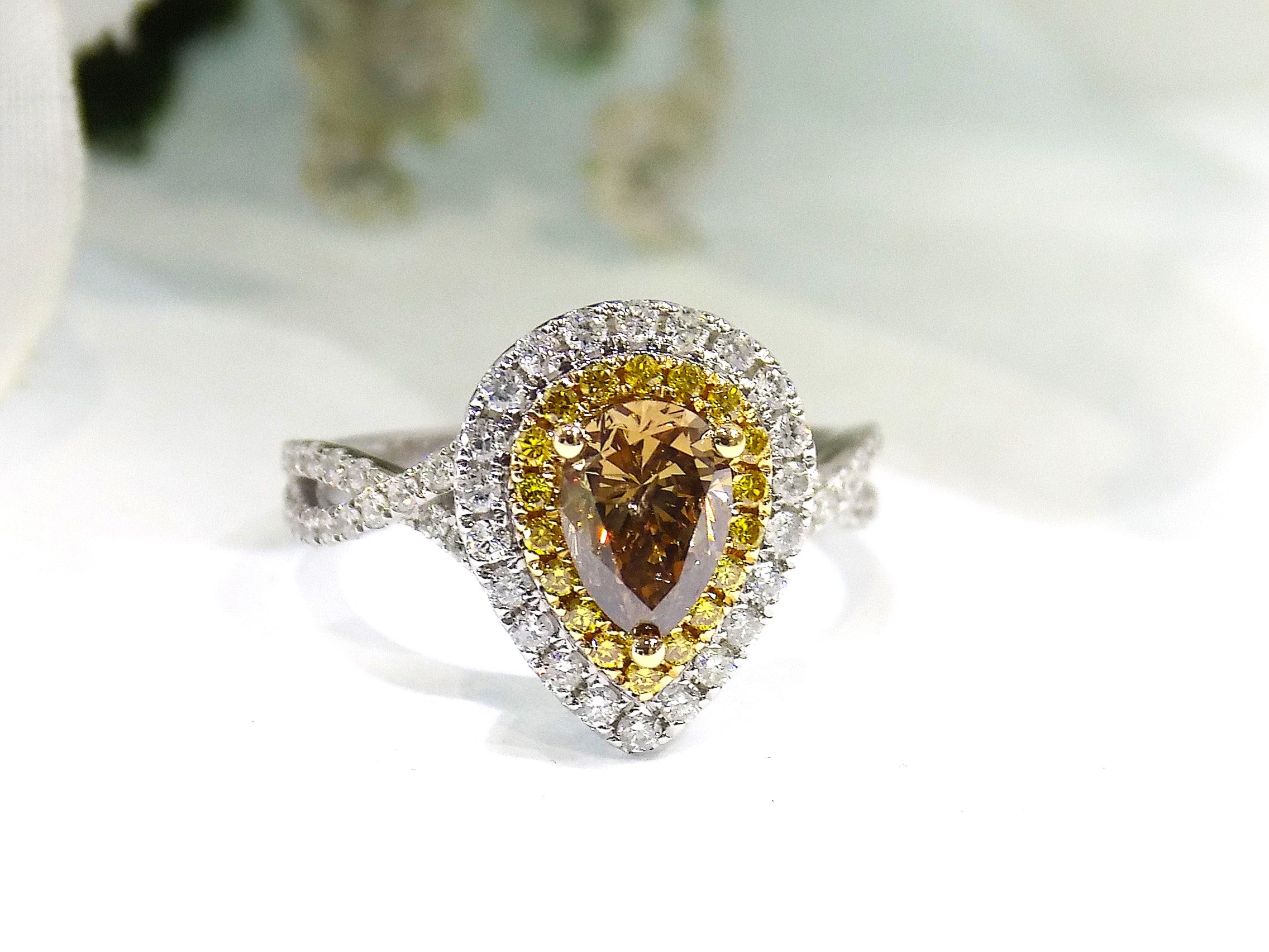 This is a 1.69ct total weight genuine natural pear shape chocolate diamond ring with canary yellow and white diamond accents in white gold with a white background.