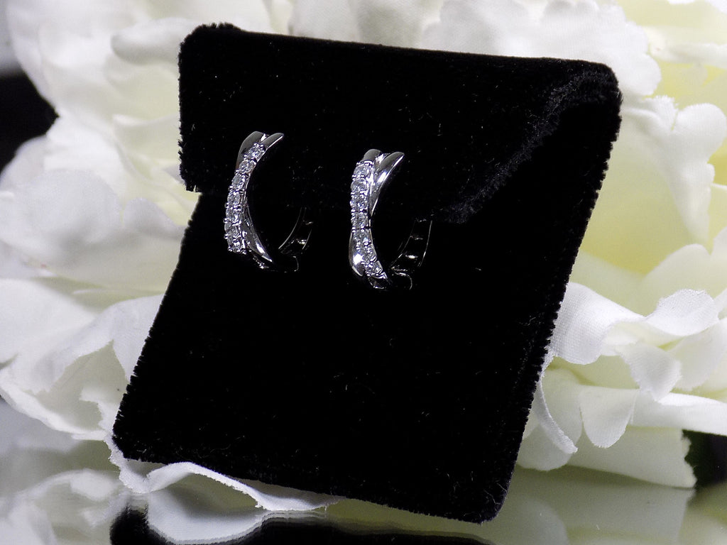 This is a side view of a pair of criss-cross huggie diamond earrings in white gold.
