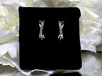 This is a pair of criss-cross huggie diamond earrings in white gold.