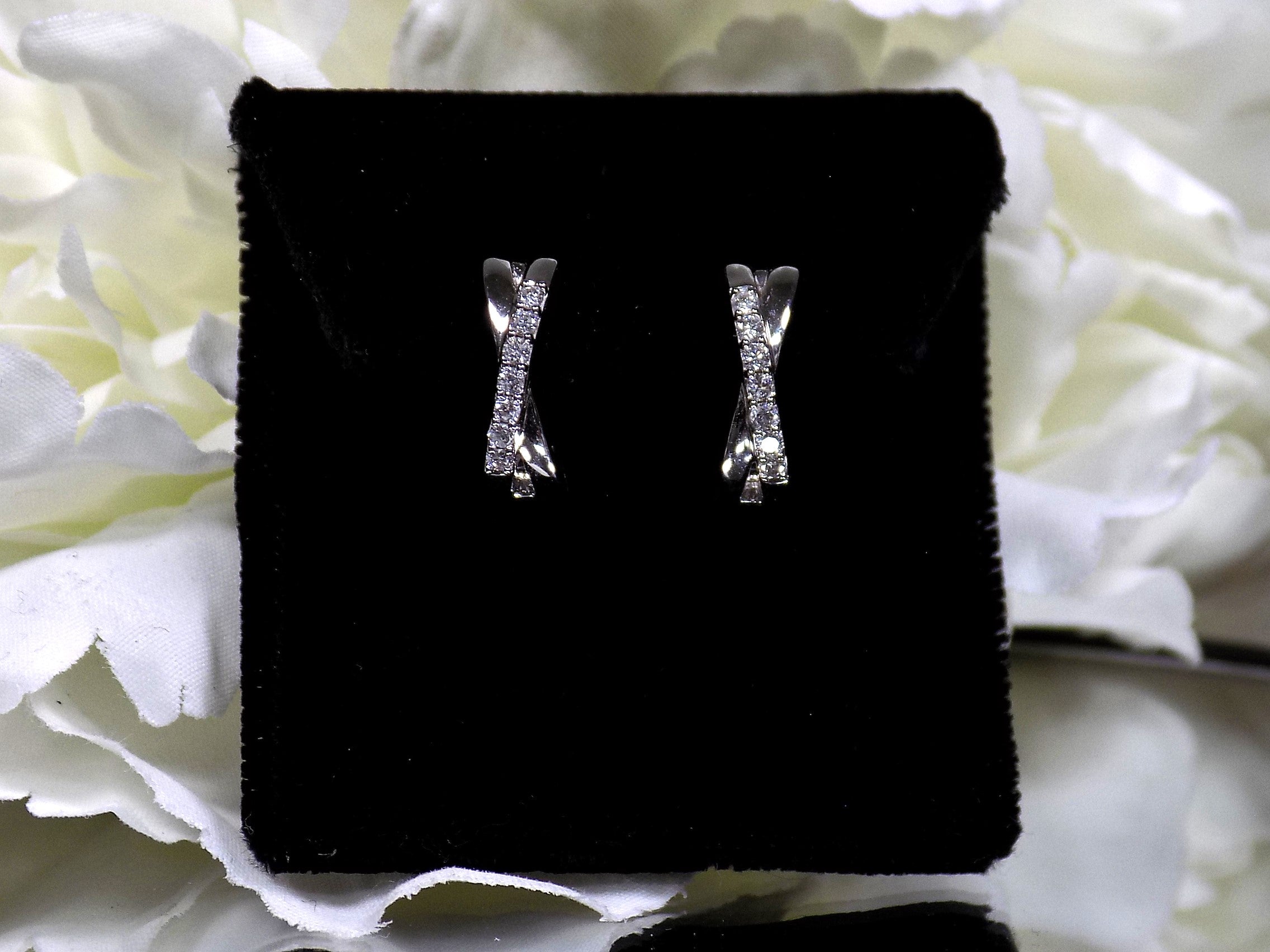 This is a pair of criss-cross huggie diamond earrings in white gold.