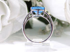This is a tension set or channel set 4.00ct natural cushion cut blue topaz solitaire ring in 14K white gold on a white background.