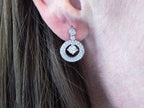 These are 1.34ct total weight natural round brilliant dancing diamond circle earrings in 14K white gold in a ladies ear.