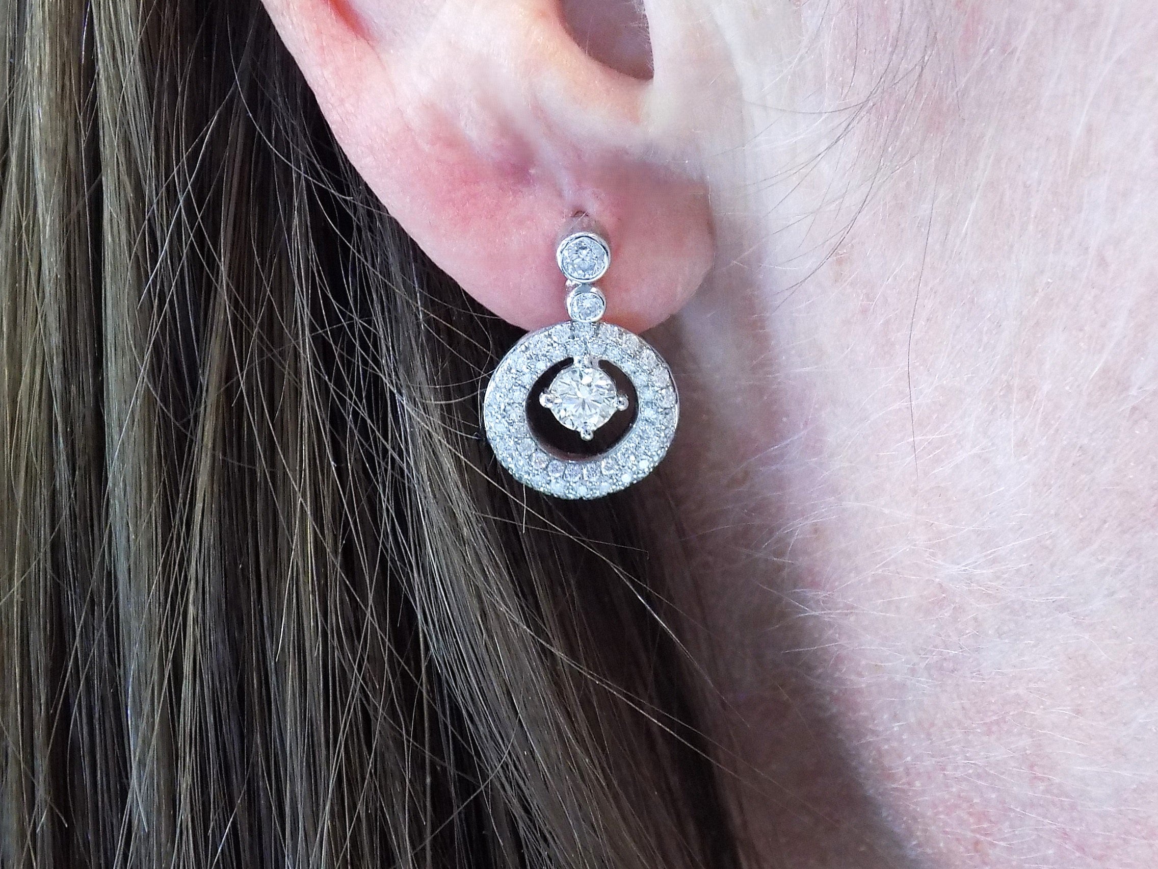 These are 1.34ct total weight natural round brilliant dancing diamond circle earrings in 14K white gold in a ladies ear.