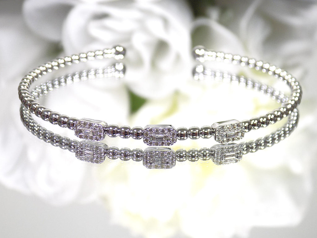 .25ct natural emerald cut and round diamond flex bracelet in 10K white gold.