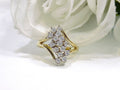 This is a 1ct total weight natural diamond waterfall style cluster ring in yellow gold with a white flowery background.
