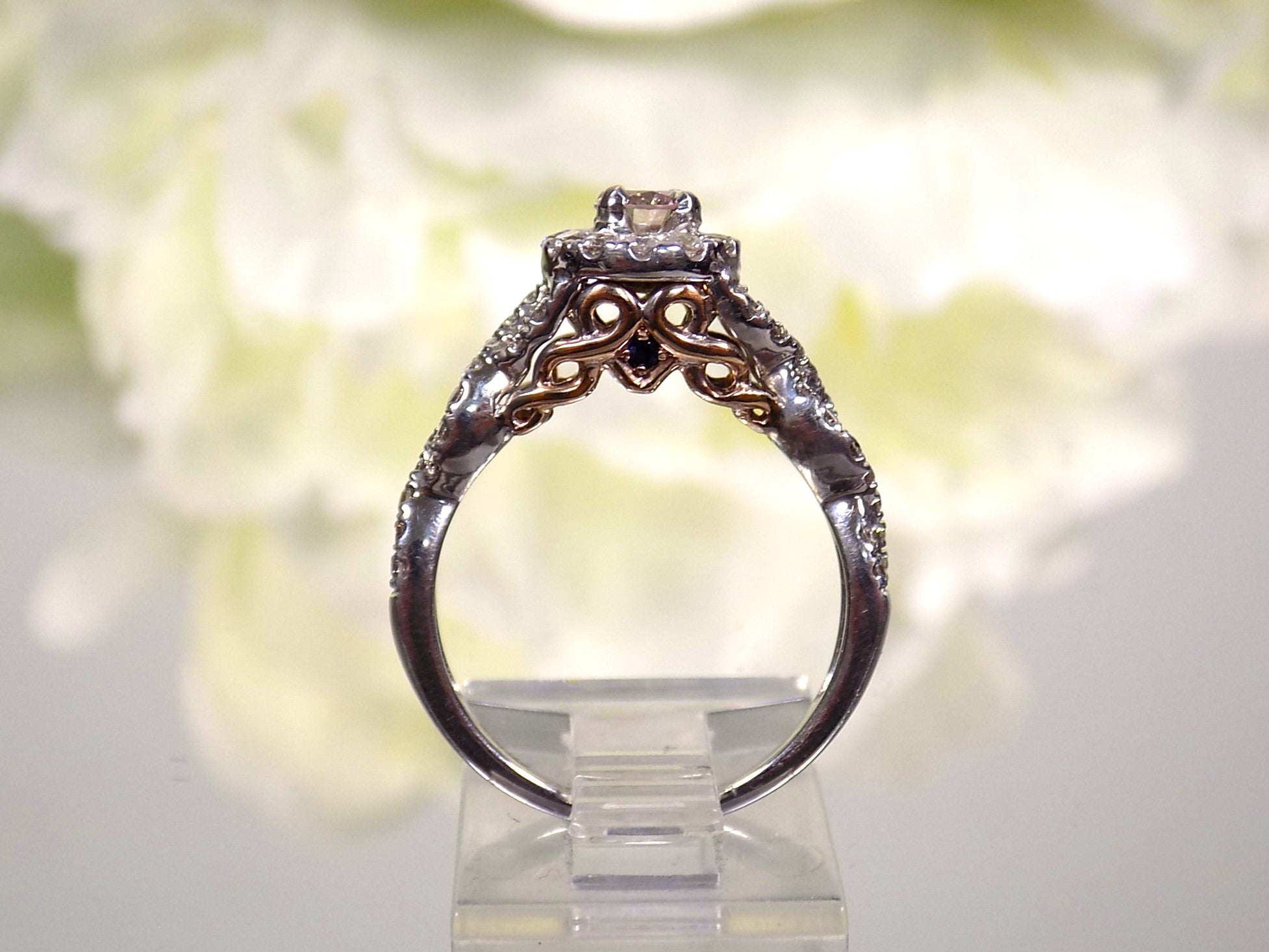 This is a side view of just the engagement ring that goes with a women's 2-piece wedding set which includes the engagement ring and matching band weighing 1.02ct in natural diamonds in white gold with rose gold accents on a white background