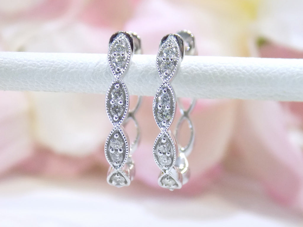 This is a pair of scalloped diamond hoop earrings in white gold.