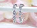 This is a pair of scalloped diamond hoop earrings in white gold.