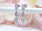 This is a pair of scalloped diamond hoop earrings in white gold.