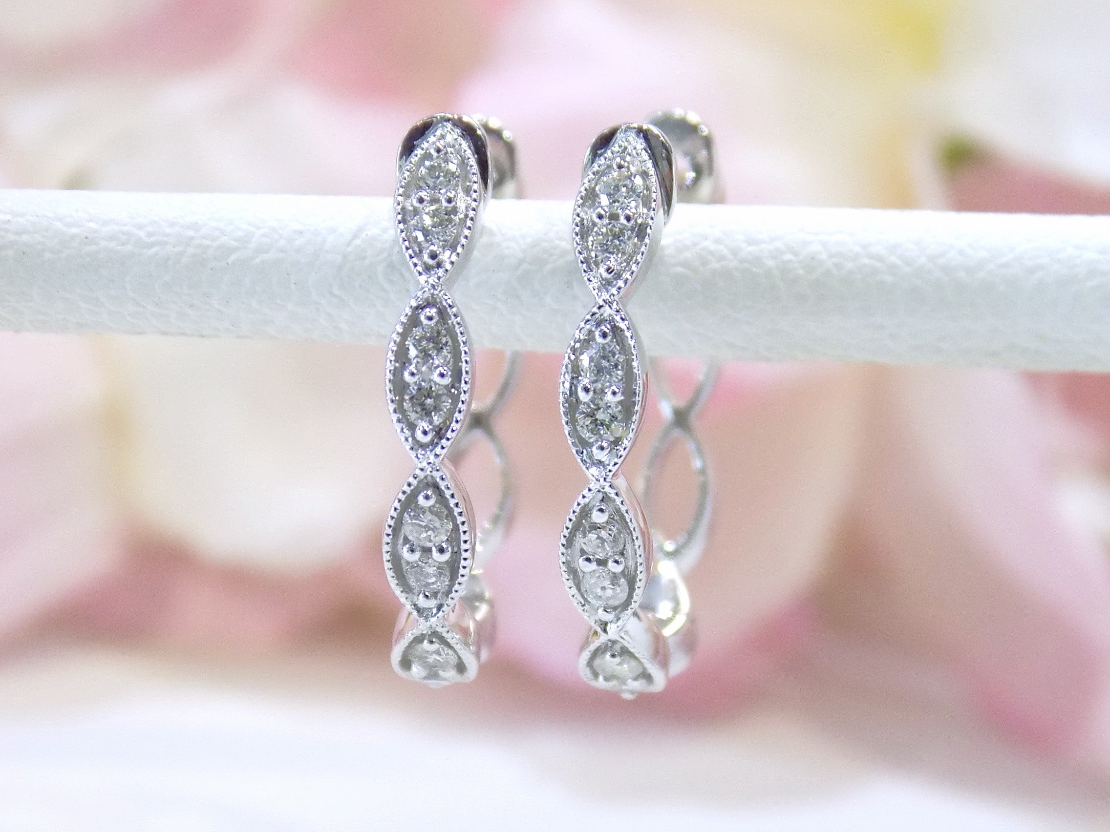 This is a pair of scalloped diamond hoop earrings in white gold.