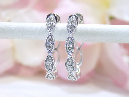 This is a pair of scalloped diamond hoop earrings in white gold.