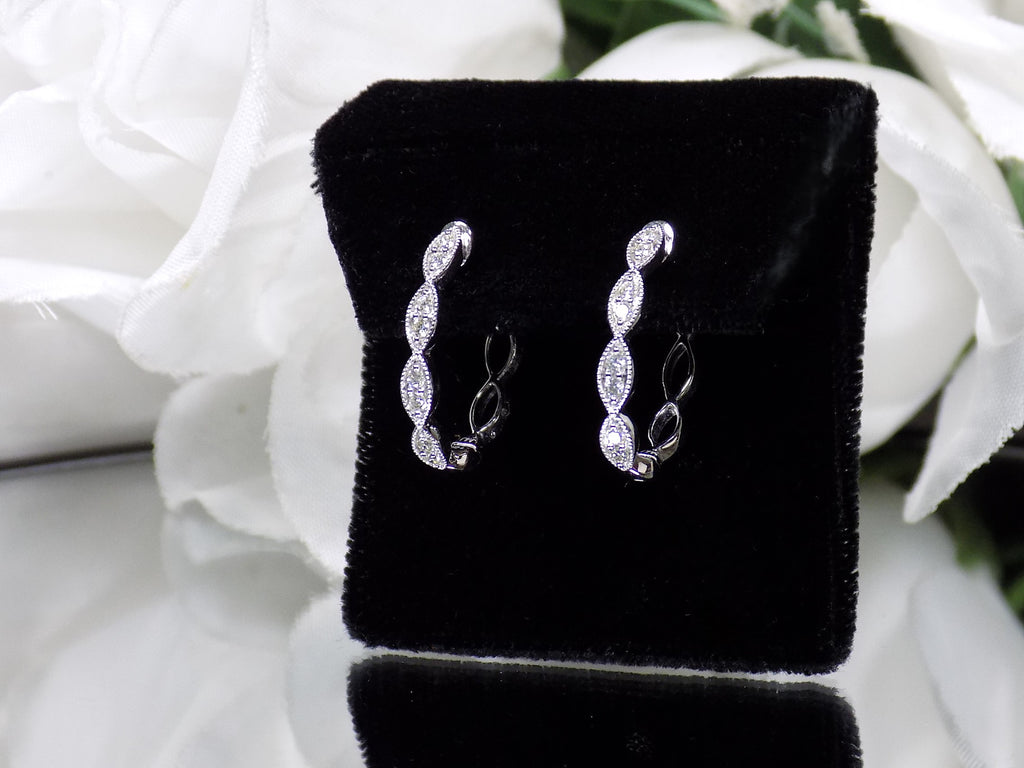 This is a pair of scalloped diamond hoop earrings in white gold.