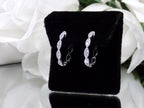 This is a pair of scalloped diamond hoop earrings in white gold.