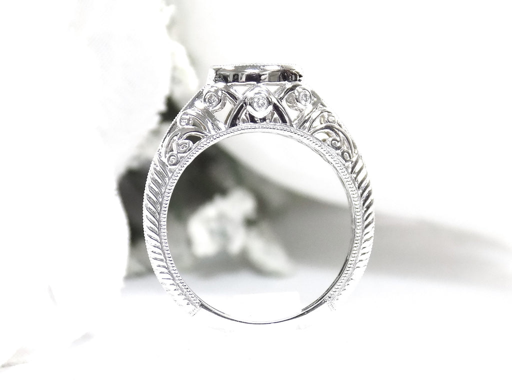 This is a bezel set marquise shape diamond set sideways in a white gold filigree ring shown from the side with a white background.