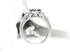 This is a bezel set marquise shape diamond set sideways in a white gold filigree ring shown from the side with a white background.