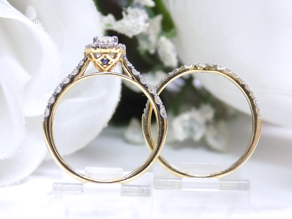 This is a side view of both an oval shape diamond engagement ring and its matching band in yellow gold with white gold prongs and a white background.
