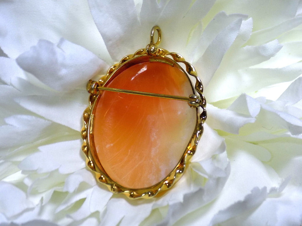 This is a back side view of a genuine ladies' cameo and brooch set in yellow gold with white flower background.