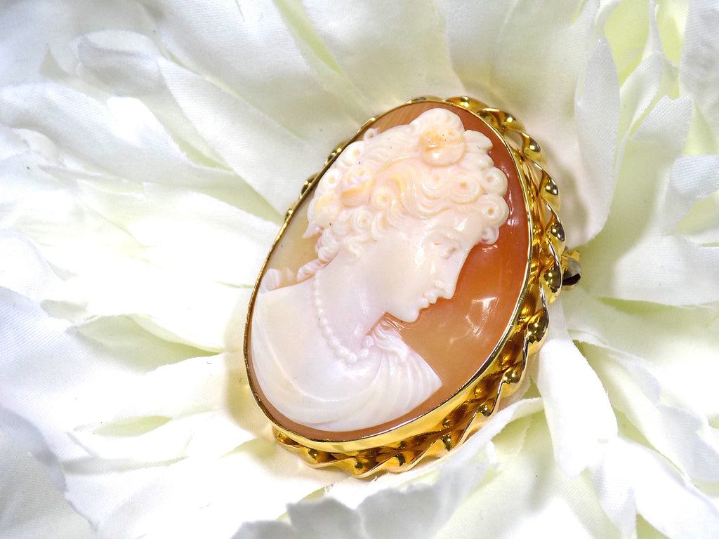This is genuine ladies' cameo and brooch set in yellow gold with white flower background.