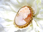 This is genuine ladies' cameo and brooch set in yellow gold with white flower background.