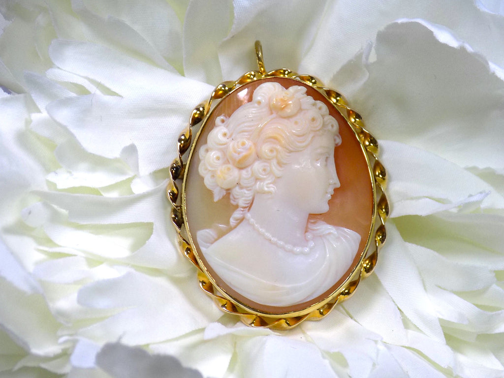This is genuine ladies' cameo and brooch set in yellow gold with white flower background.