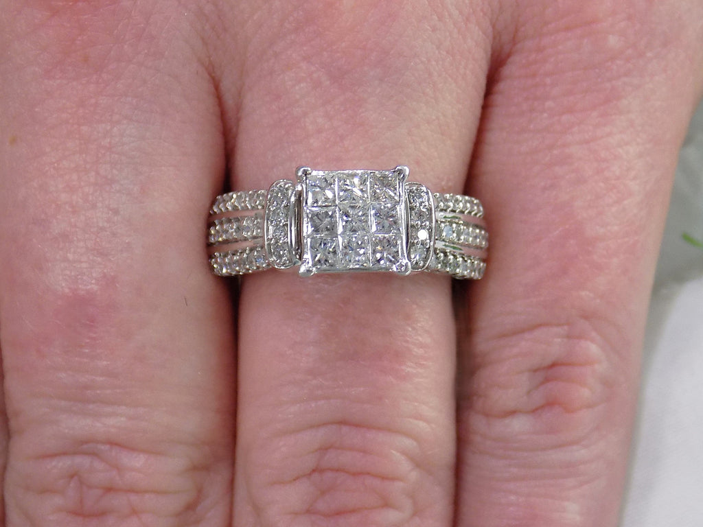 This is an Estate ring with 1.00ct total weight invisible set diamond ring with natural princess cut and round diamonds in white gold on a ladies finger.